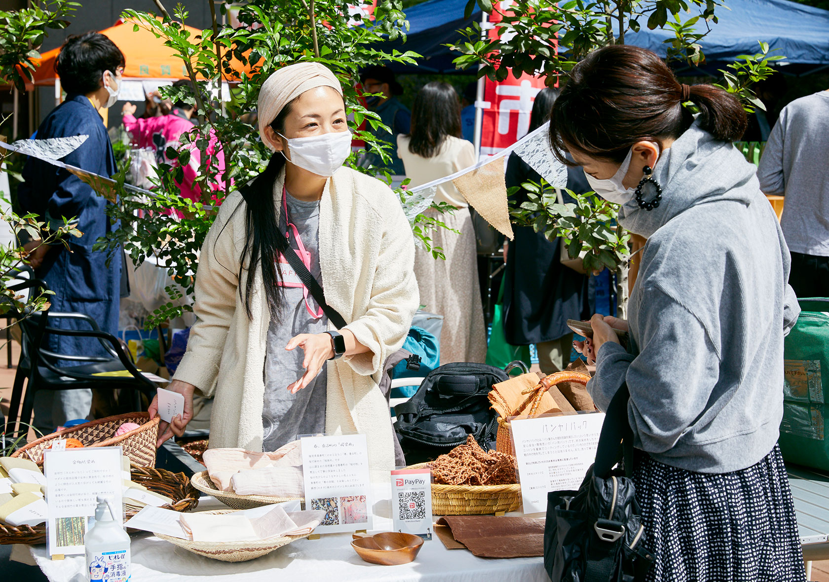 マーケット会場で自分の作品を説明する村上さん