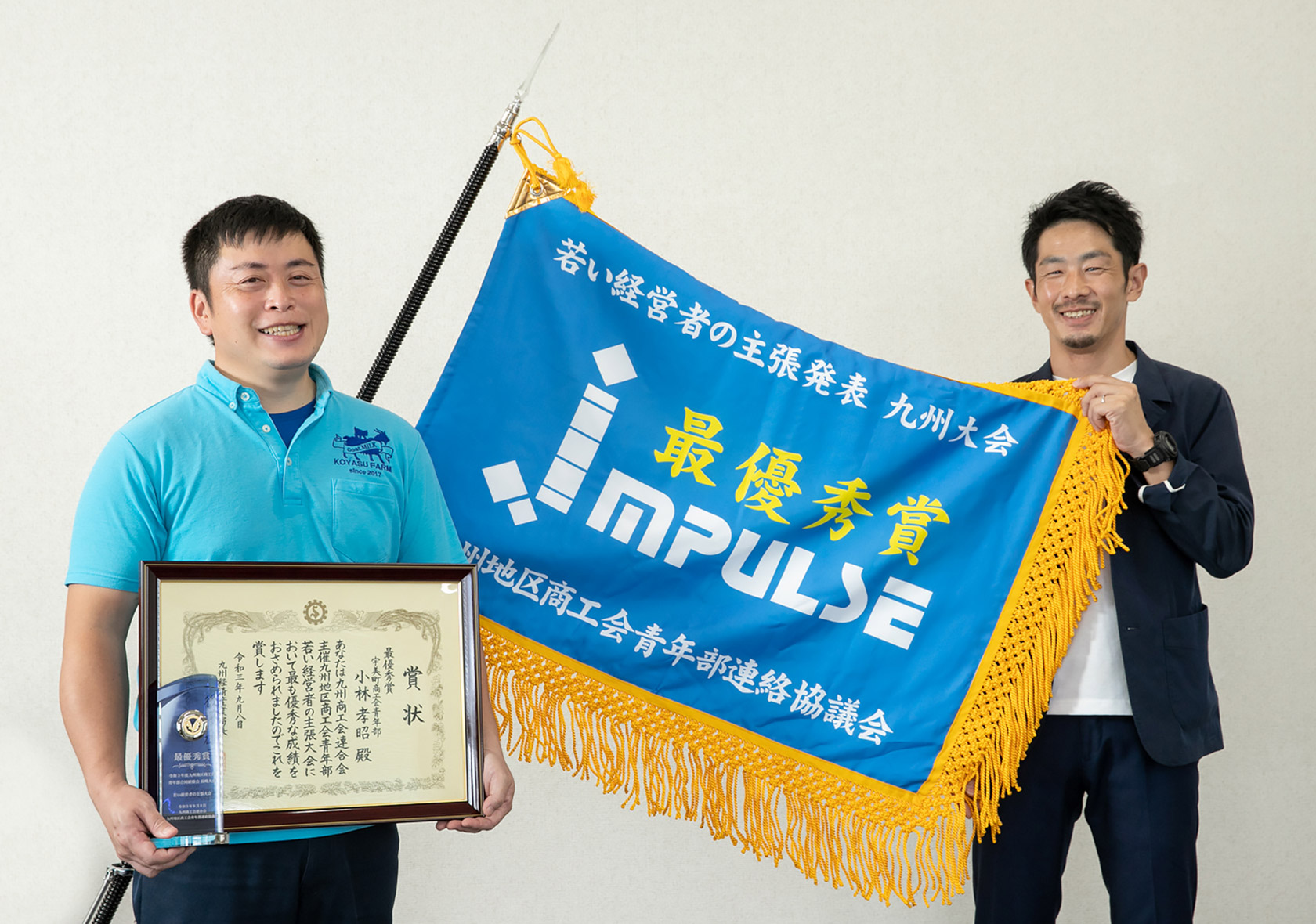 9月に行われた「青年経営者の主張 九州大会」で最優秀賞に選ばれたKOYASU FARM代表の小林さん(左)。共に喜ぶ山元青年部長(右)と一緒に